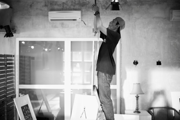 Electrician working on wiring from ladder